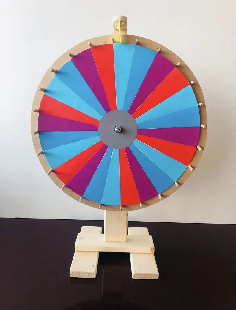 Buntes Glücksrad aus Holz mit blauen, roten, lila und türkisen Feldern